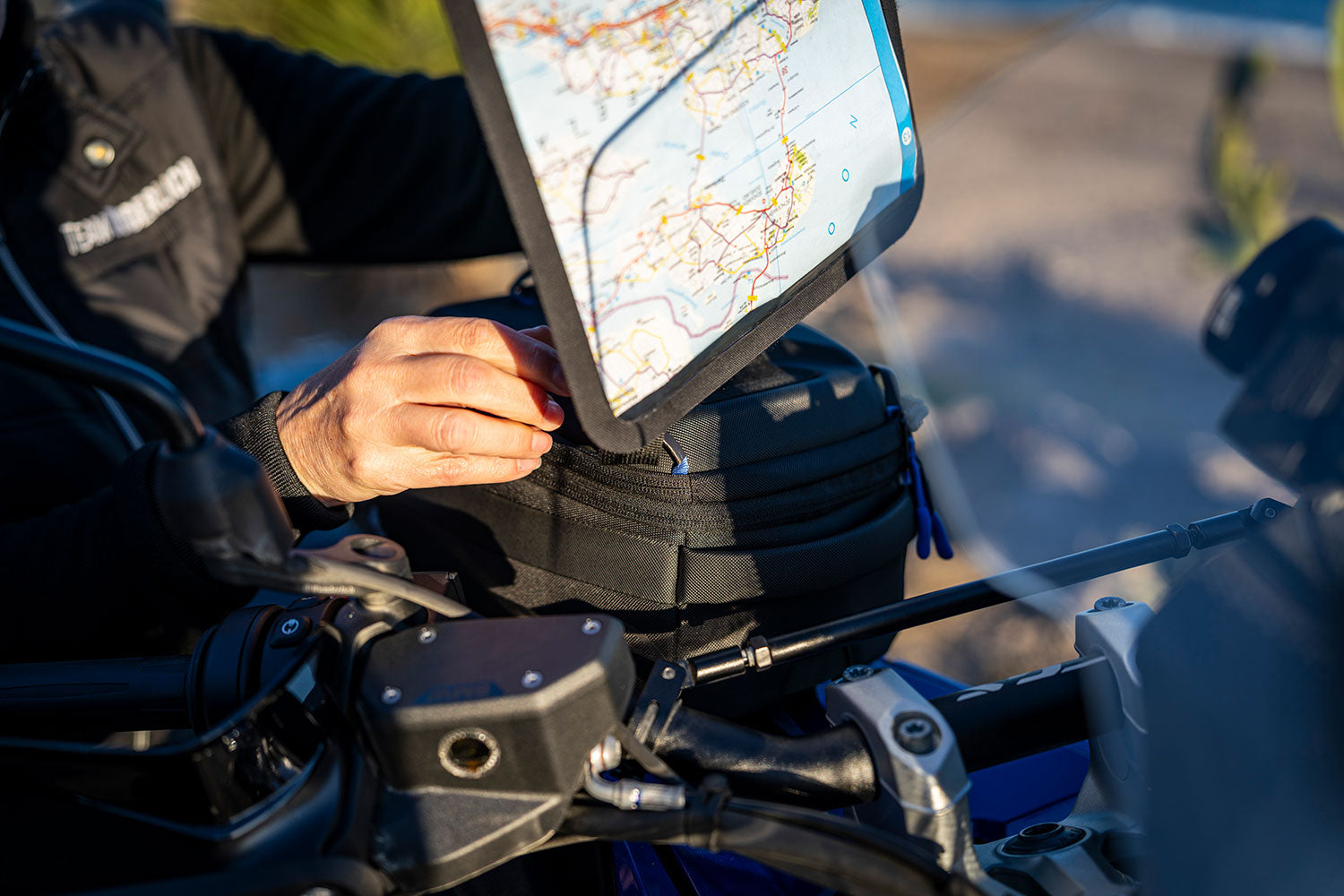 Person using a navigation device on a motorcycle with a blurred background